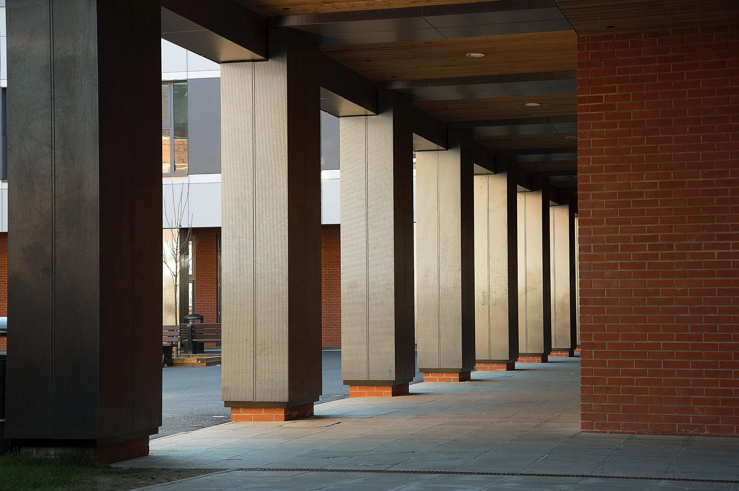 A covered colonnade designed by dhp — structure, brickwork and lighting working as one